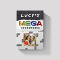 Personalized Mega Crossword book on a gray background, featuring a custom cover name and a personal photo creatively embedded within a crossword grid design.