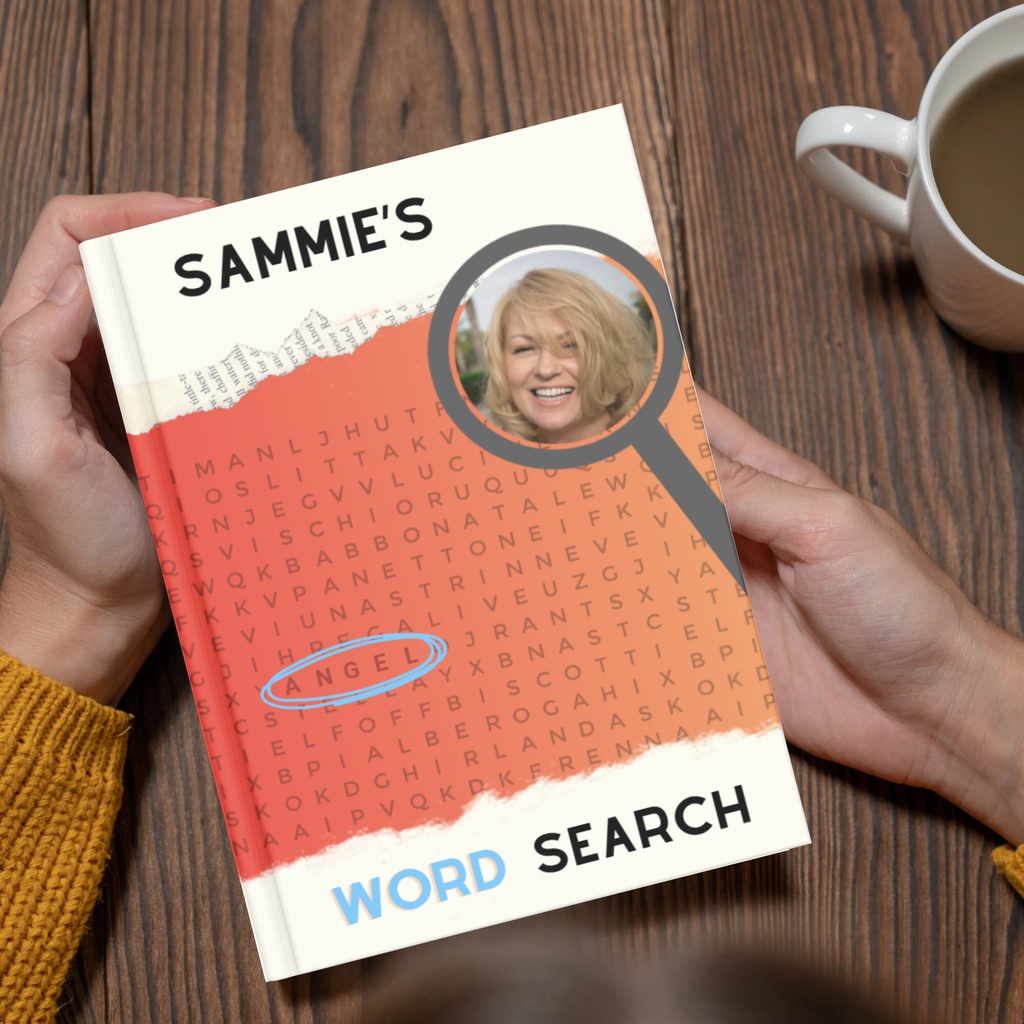 Book titled 'Sammie's Word Search' held by a person on a wooden surface with a cup of coffee.