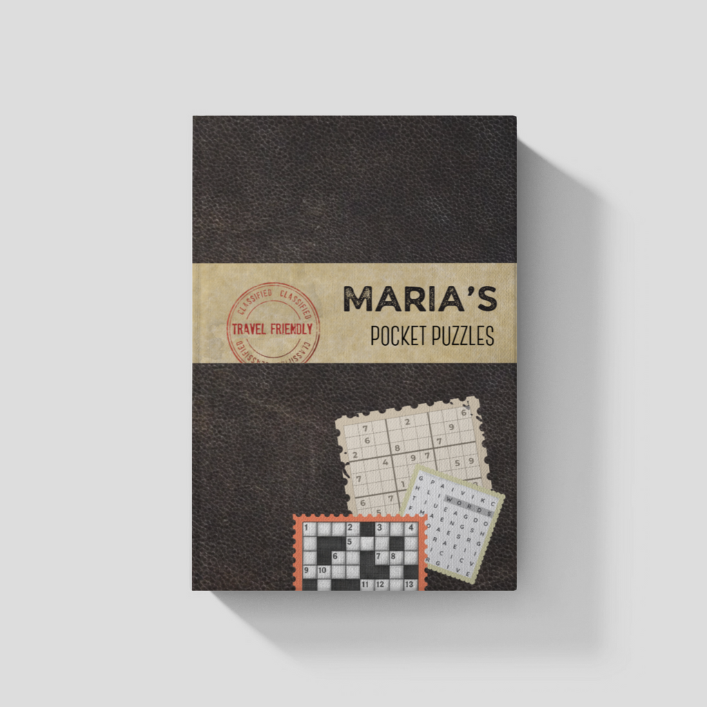 A personalized Pocket puzzle book shown upright on a light gray background. Teh book is shown with the matte black cover and a tan band across the middle with the personalization, a red circular stamp graphic, and small puzzle card illustrations near the bottom.