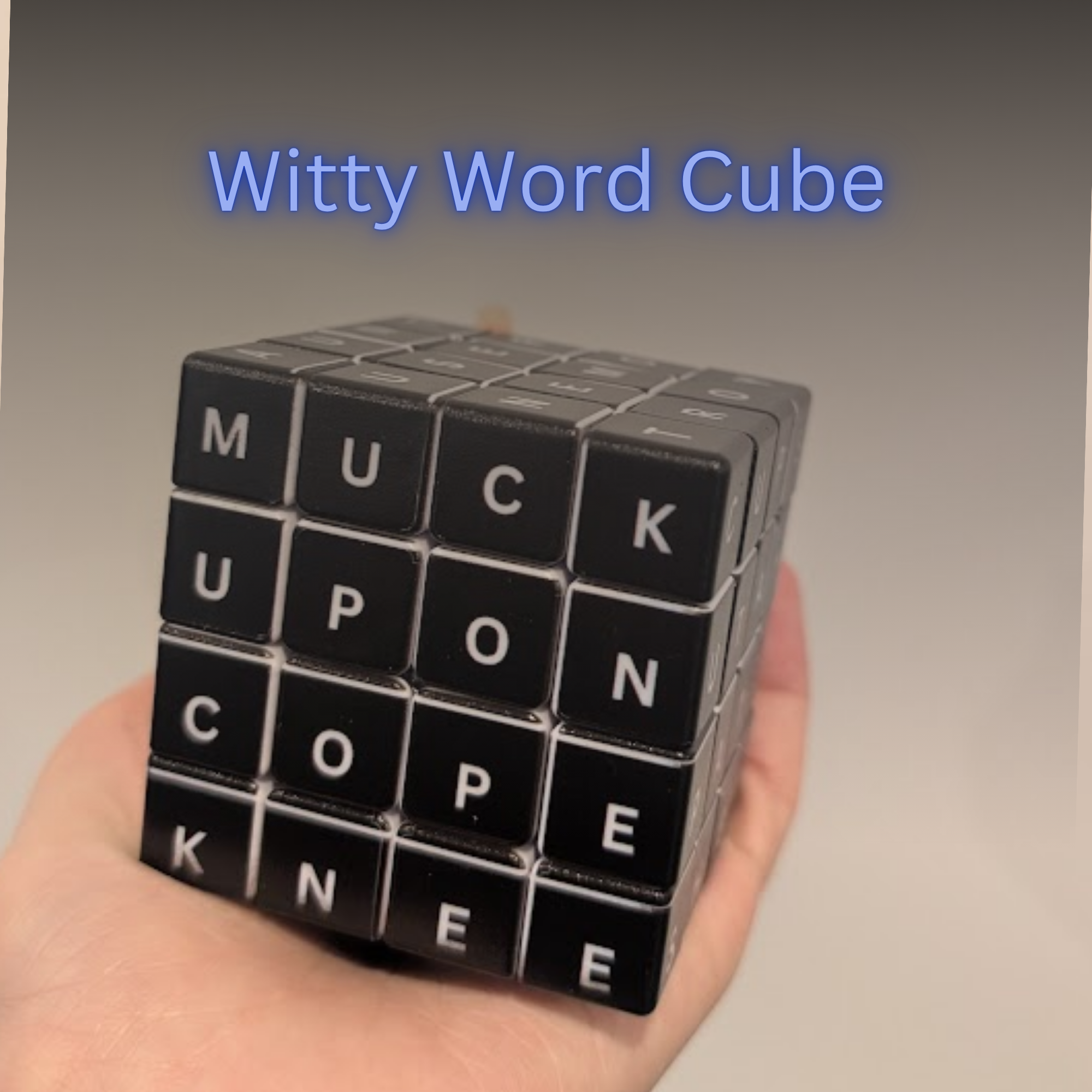 Black Witty Word Cube held in a hand with a gray background
